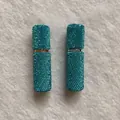 Close-up detail of two elegant teal rhinestone-encrusted 10ml portable perfume sprayers - Pure Lake Blue