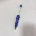 Close-up detail of a handmade blue rhinestone ballpoint pen with charming pink hearts. - Deep Blue with AB Rhinestone Heart