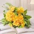 Vibrant yellow artificial flower bouquet with green leaves presented on an open book. - Yellow