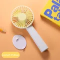 Detailed view of the lemon yellow portable handheld fan with its detachable base. - N13 Base Model / Lemon Yellow