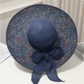 Vue détaillée d'un chapeau de paille bleu avec taches colorées et grand nœud - M / Bleu marine