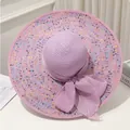 Vue détaillée d'un chapeau de paille violet à larges bords avec confettis et un grand nœud papillon - M / Violet
