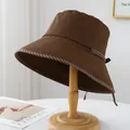 Détail d'un chapeau de pêcheur marron avec nœud décoratif sur un support en bois - M (56-58cm) / 12100 Café