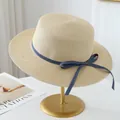 Detailed view of high-quality raffia straw sun hat with stylish blue ribbon bow decoration - Off White