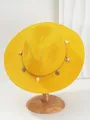 Detailopname van een gele Panama strohoed met schelp- en zeesterren decoratieve band - M (56-58cm) / Geel