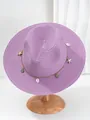 Detail van een paarse Panama strohoed met schelp- en zeesteraccessoires op houten standaard. - M (56-58cm) / Paars