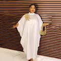 Detailed view of white African kaftan dress with gold embroidery and batwing sleeves. - Dresses / White