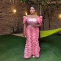 Detailansicht eines rosa afrikanischen Abendkleids mit 3D-Blumenstickerei und Pailletten. - Rosa
