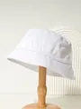 Detailed macro view of a white cotton bucket hat on a wooden display stand for outdoors - M (56-58cm) / White