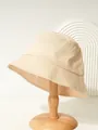 Close-up of a beige cotton bucket hat displayed on a minimalist wooden hat stand - M (56-58cm) / Beige