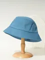 Seitenansicht eines blauen Baumwoll-Fischerhuts auf einem Holzständer - M (56-58cm) / Blau
