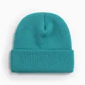 Gros plan d'un bonnet en tricot bleu sarcelle montrant sa texture en acrylique. - Style Tricoté à Bord Replié / Bleu saphir