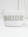 Close-up of white woven straw bag featuring pearl and rhinestone BRIDE patch detail - Pearl Style