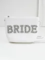 Close-up detail of white straw bridal handbag with sparkling rhinestone BRIDE letters - White Zirconia Style