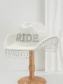 Close-up of white wool hat with rhinestone BRIDE letters and sparkling fringe - White Border Color Rhinestone BRIDE Tassel / White