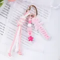 Close-up detail of a pink hand-woven rope keychain featuring a Mama charm and star beads - Pink