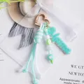 Close-up detail of a handmade turquoise braided keychain with a heart clasp and Mama tag - Green
