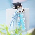 Detailed macro shot of a light blue hand-woven rope keychain with Mama charm and beads - Blue