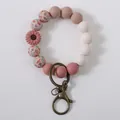 Pink silicone bead wristlet keychain with daisy flower charm and cactus print beads. - Rouge Red