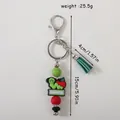 Silicone caterpillar keychain featuring red apple book charms and green tassel beads - Sea Green
