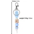 Blue silicone bead keychain with rose pendant and butterfly wood bead - Cyan