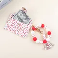 Close-up of baseball-themed silicone bead keychain with leather card holder and tassel - Red Baseball