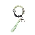 Detailed macro view of the silicone beaded keychain featuring a cross charm and sage green tassel - Leopard Print Light Green