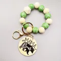 Detalle de las cuentas de tenis y el colgante de madera grabado MAMA Bear en el llavero. - Estilo de Béisbol Verde