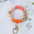 Premium silicone beaded wristlet keychain with elegant floral patterns and gold-tone clasp. - Orange