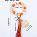 Handmade silicone bead wristlet keychain with cow print, mama wood charm, and tassel. - Orange Red
