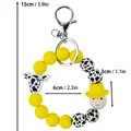 Süßer gelber Silikonperlen-Schlüsselanhänger mit Kuh-Anhänger und einer Smiley-Figur - Smiley-Stil / Gelb