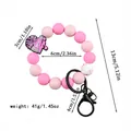 Pulsera llavero de cuentas de silicona rosa con amuleto cheer y dimensiones del producto. - Estilo Cheerleader / Rosa