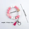 Handmade pink and white silicone bead bracelet keychain with a stylish tassel and leaf charm. - Pink