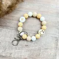 Gelber Silikonperlen-Schlüsselanhänger mit Schachbrettmuster, Blume und Smiley-Anhänger - Armband Ring Stil (K-1567) / Hellkaffee