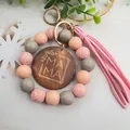 Primer plano de llavero MAMA de cuentas de madera con borla rosa - Rosa