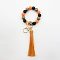 Detail view of handmade zebra stripe beaded wristlet keychain with orange leather tassel - Orange
