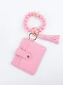 Macro view of pink silicone bead bracelet keychain with PU leather card holder and tassel - Peach Style