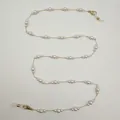 Élégante chaîne de lunettes en perles et cordon pour masque posés sur fond blanc - Style Perle Dégradée (S-101) / Or