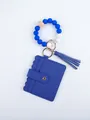 Close-up of blue PU leather card holder with silicone bead wristlet and tassel accent - Blue Style