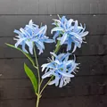 Nahaufnahme von drei blauen künstlichen Spinnenlilien mit zarten weißen Staubfäden - Hellblau