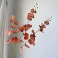 Detailed view of vibrant orange artificial Dancing Lady Orchids with realistic petals - Orange