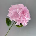 Detailed view of a realistic pink artificial hydrangea flower on a single green stem. - Pink
