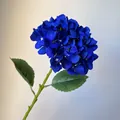 Detailed close-up of a single stem blue artificial hydrangea with green leaves. - Sapphire Blue