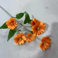 Detailansicht von sechs leuchtend orangefarbenen Kunstblumen mit grünen Blättern. - Orange