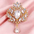 Primo piano di un'elegante spilla a corona dorata con dettaglio in cristallo scintillante. - Oro