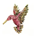 Detailed macro view of vibrant rhinestone hummingbird brooch with vintage gold finish - Antique Gold And Fuchsia