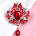 Vista dettagliata della spilla a corona vintage con cristalli rossi e pendente a goccia - Argento + Rosso
