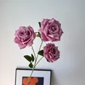 Detailed view of three purple artificial roses with realistic layered petals and stem. - 3-Head Bean Paste Purple Rose