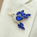 Detail shot of a sparkling blue hummingbird brooch with intricate rhinestone accents. - Sapphire Blue