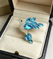 Close-up of elegant gold hummingbird brooch with blue and white crystals in gift box - Sky Blue